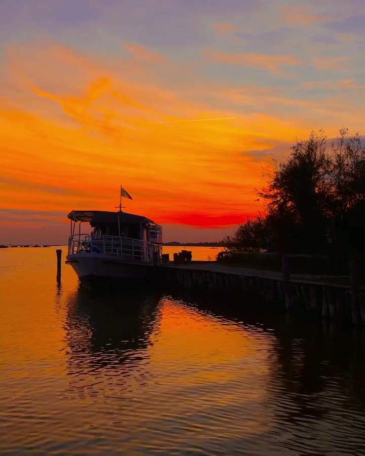 Explore Comacchio Delta's Serene Sunset and Boat Scene