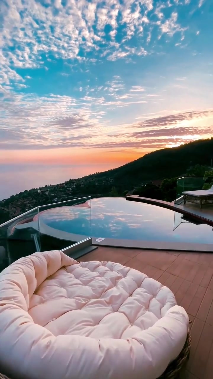 Luxury Poolside View: Sunset, Mountains, and Coastline