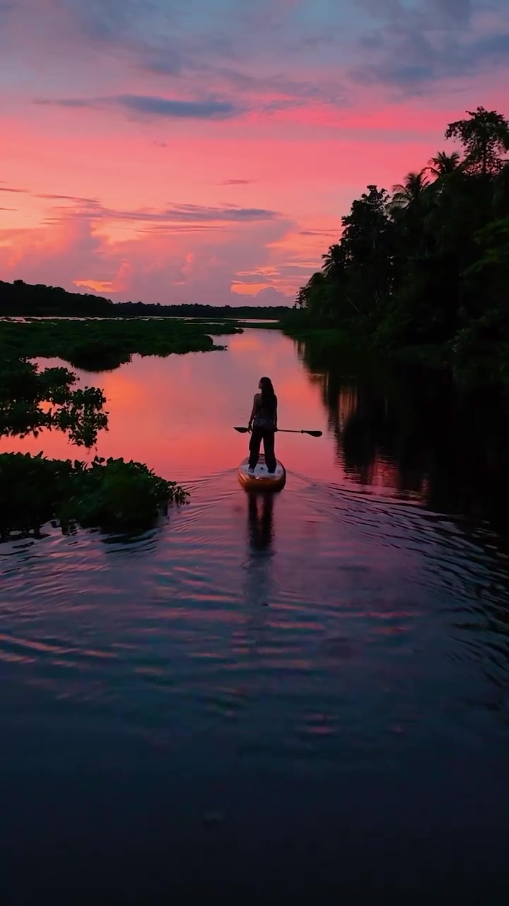 Paddleboarding at Sunset: Calm River, Vibrant Skies