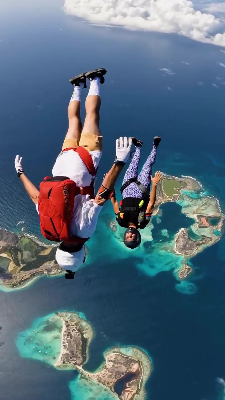 Skydiving Duo's Aerial Maneuver Above Tropical Island