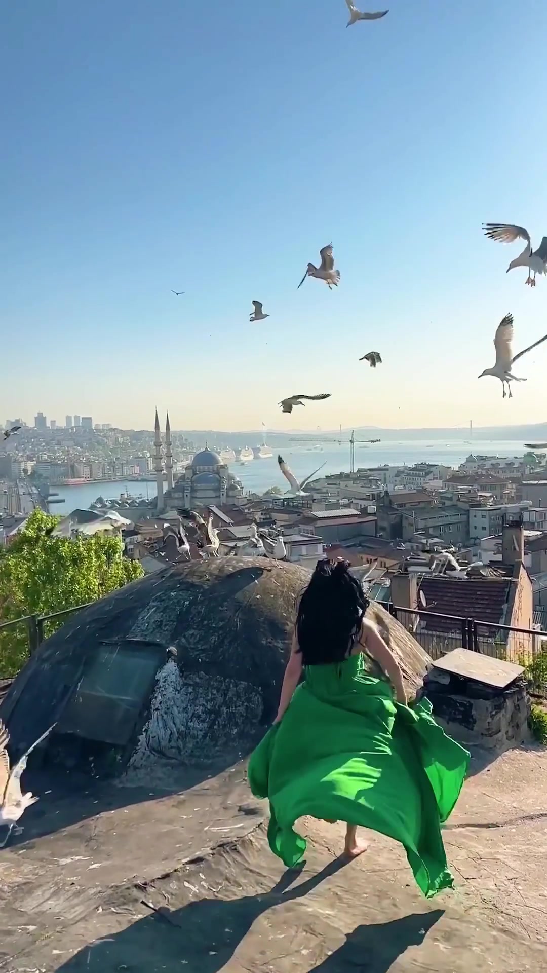 Istanbul Rooftop View: Person in Green Dress Twirling
