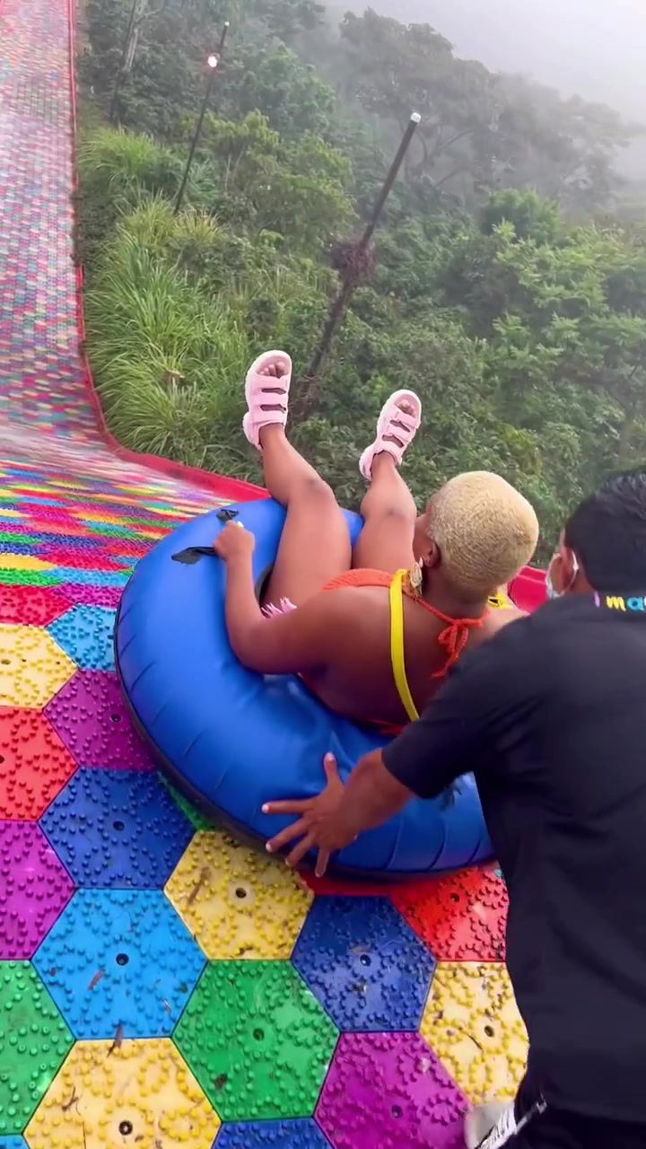 Riding a Long Colorful Water Slide in an Inflatable Tube